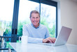 Smiling man using laptop at table
