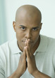 Man with hands together, looking at camera