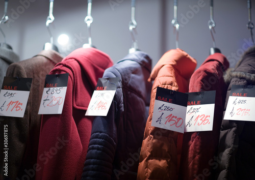 Photo: Coats on rack with tags showing sale prices Coats on rack with tags showing sale prices