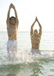 Two men emerging from water