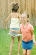 Girls jumping in sprinkler
