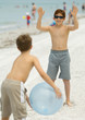 Boys playing with ball on beach