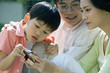 Family looking at digital camera together, close-up