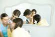 Young female friends putting make-up on younger girl