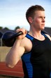 Young man doing kettlebell exercise outside
