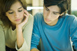 Students studying together, looking down, portrait