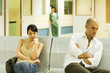 Adults sitting in hospital waiting room, looking away