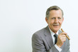 Senior businessman smiling at camera, holding cigar, portrait