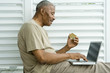 Senior man using laptop, making on-line purchase with credit card