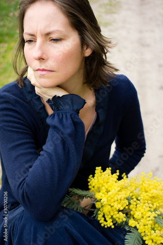 Photo: femme tenant un brin de mimosas femme tenant un brin de mimosas