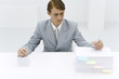 Businessman writing on two stacks of paper, one large, one small, pencil in each hand