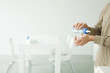 Father holding baby bottle, checking temperature on wrist, cropped view