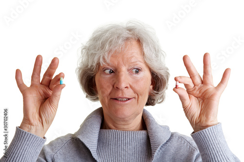 Foto: Seniorin vergleicht zwei Tabletten Seniorin vergleicht zwei Tabletten