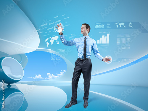 Photo: Young businessman navigating holographic virtual interface Young businessman navigating holographic virtual interface