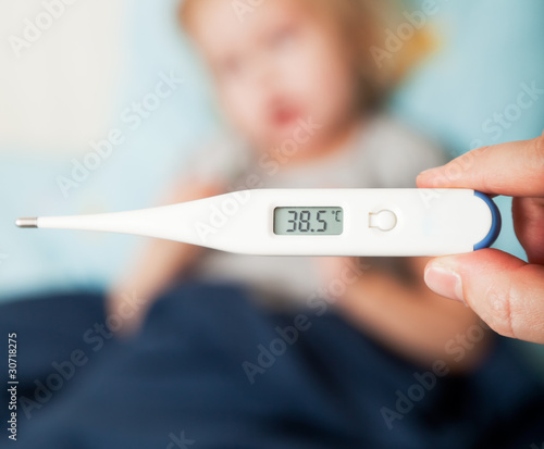 Photo: a mother measures the temperature of her daughter a mother measures the temperature of her daughter