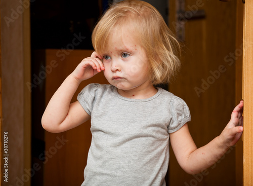 Photo: a sick girl is near the door a sick girl is near the door