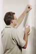 Man Putting Adhesive Tape On A Wall
