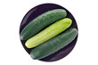 three whole cucumbers in a dish, one peeled three whole cucumbers in a dish, one peeled