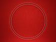 Red stitched circle shape on leather background