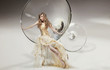 Perfect young beauty sitting on martini glass