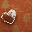 dekoriertes Herz aus Lebkuchen auf weihnachtlichem Untergrund