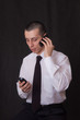 young businessman talking on two phones young businessman talking on two phones