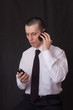 young businessman talking on two phones young businessman talking on two phones