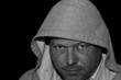 menacing man in hood isolated on black