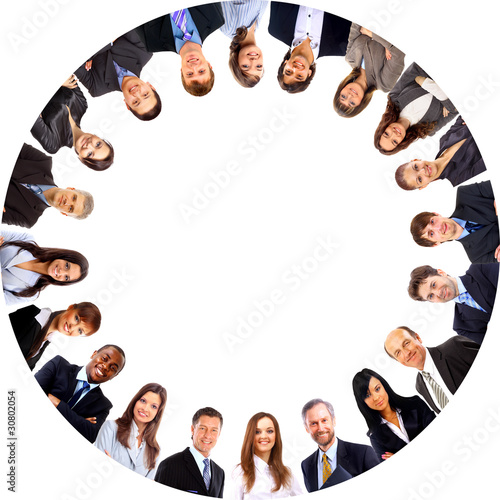 Photo: Group of business people standing in huddle, smiling, Group of business people standing in huddle, smiling,