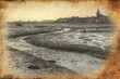 Low tide harbour at sunset with nearby town in distance retro gr