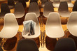 several rows of white plastic chairs; brochure standing on chair