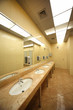 sinks and mirrors in public restrooms, yellow tiles on floor