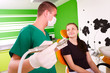 Foto: A young male dentist working, treating a young female patient. A young male dentist working, treating a young female patient.