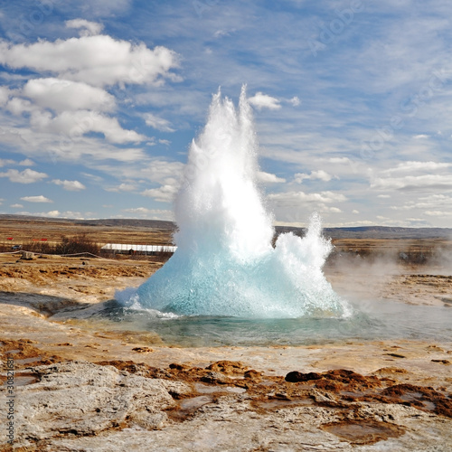 Photo : Famous Geyser eruption in a sunny day, Iceland Famous Geyser eruption in a sunny day, Iceland