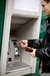 A young man using a cash machine A young man using a cash machine