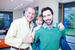 Happy grandfather, father and son in living room