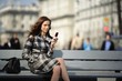 Photo : beautiful young woman with a cellphone with city on background beautiful young woman with a cellphone with city on background