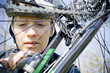 Woman repairing bicycle outdoors Woman repairing bicycle outdoors