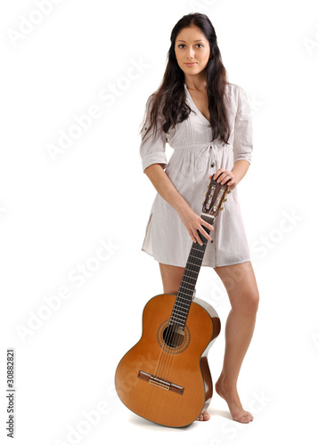 Photo: Young beautiful brunette girl in white chemise with acoustic gui Young beautiful brunette girl in white chemise with acoustic gui