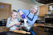 Grandmother and granddaughter baking in kitchen