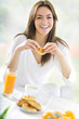 Foto: young beautiful woman at breackfast young beautiful woman at breackfast
