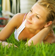 Beautiful healthy Young Woman relaxing on the green grass Beautiful healthy Young Woman relaxing on the green grass