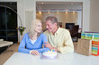Couple celebrating birthday with birthday cake and gift bags