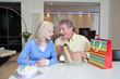 Couple celebrating birthday with birthday cake and gift bags