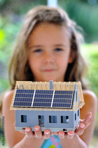 Foto: Fillette présentant une maquette de maison. Fillette présentant une maquette de maison.