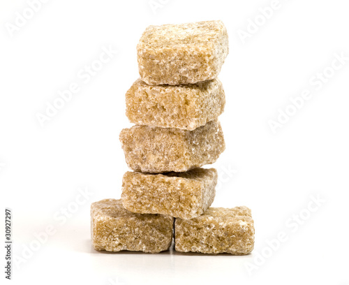 Photo: Tower of brown sugar cubes on white background Tower of brown sugar cubes on white background