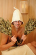 Foto: Young handsome man in a towel relaxing in a russian wooden sauna Young handsome man in a towel relaxing in a russian wooden sauna