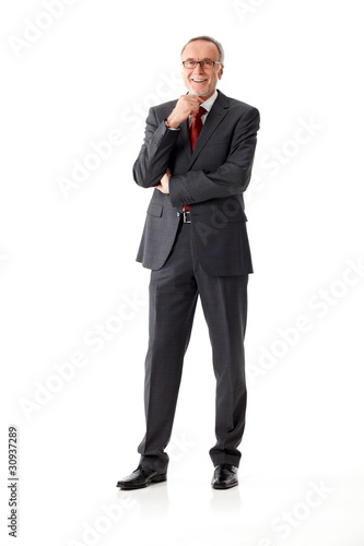 Foto: Isolated mature business man, standing, hand on chin Isolated mature business man, standing, hand on chin