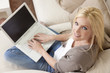 Young Woman Using Laptop Computer At Home on Sofa