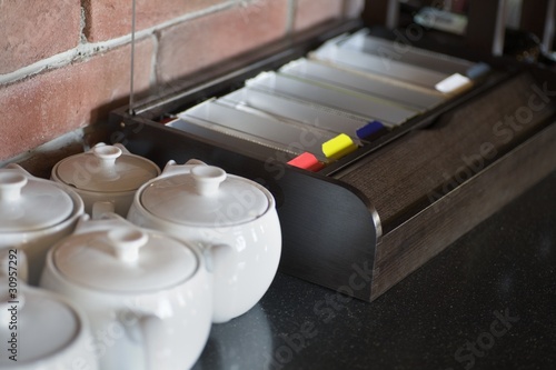 Photo: Little china teapots lined up next to tea sachets Little china teapots lined up next to tea sachets